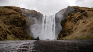 Capture of Skógafoss waterfall with visitors in Vík í Mýrdal, Iceland.